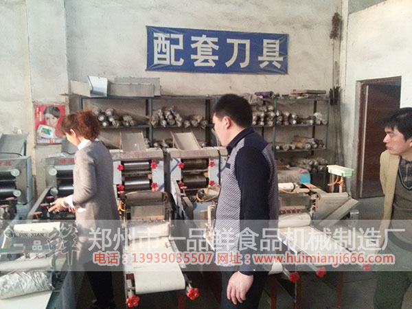 工作人員向安陽(yáng)周先生介紹HMJ-5型燴面機(jī)的特點(diǎn)