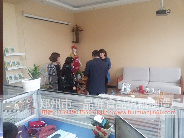 工作人員與秦先生夫婦在討論生產(chǎn)推廣事宜