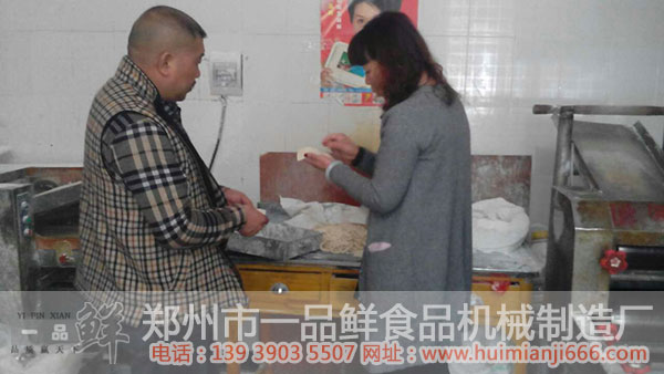 工作人員給陳先生講解機(jī)器出面的優(yōu)點