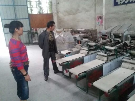 工作人員給客戶介紹不同型號燴面機的區(qū)別